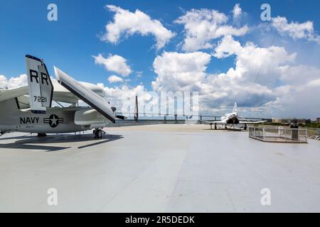 Die Arthur Ravenel Jr. Brücke überquert den Cooper River jenseits der USS Yorktown im Hafen von Charleston. Ein F-4 Phantom und ein E-1B Tracer werden angezeigt. Stockfoto