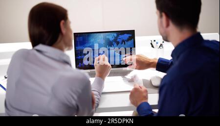 Zwei Analytiker, die KPI-Dashboard auf einem Laptop verwenden Stockfoto