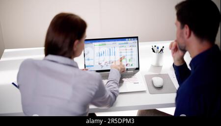 Zwei Analytiker, die KPI-Dashboard auf einem Laptop verwenden Stockfoto