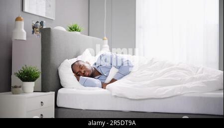 Gähnender Afroamerikanischer Mann, Der Im Bett Schläft Stockfoto
