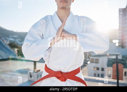 Karate, Bewegung und Disziplin mit einem Sportler in gi, trainiert in der Stadt auf einem verschwommenen Hintergrund. Fitness, Respekt oder Verbeugung mit einem männlichen Athleten Stockfoto