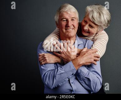 Ein himmlisches Paar. Studioporträt eines liebevollen Seniorenpaares, das vor grauem Hintergrund posiert. Stockfoto