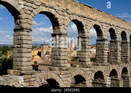 Aquädukt von Segovia (Acueducto de Segovia), Spanien. Abschnitt des Aquädukts über der Plaza del Azoguejo mit Blick auf zwei romanische Kirchentürme. Stockfoto