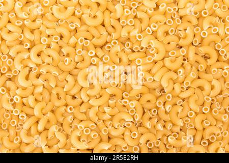 Ungekochte Chifferi Rigati Pasta Hintergrund. Fett und ungesunde Lebensmittel. Klassische Trockene Makkaroni-Textur. Italienische Kultur und Küche. Rohe Pasta Stockfoto