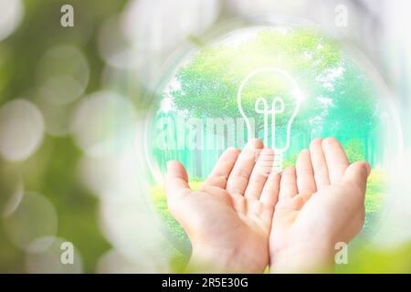 Erde in Form Wassertropfen von der Spitze der Kinderhand auf grünem Hintergrund für das internationale Wassertagkonzept oder den Weltumwelttag Stockfoto