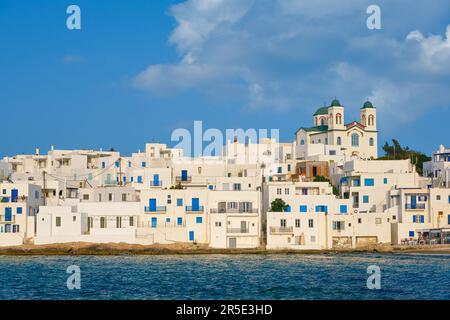 Weiß getünchte griechische Häuser und Kirche am Meer an sonnigen Tagen, Naoussa, Paros Insel, Griechenland Stockfoto