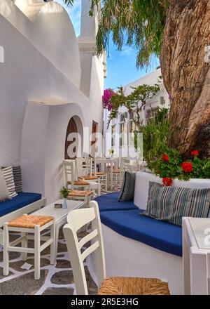 Gemütliches Café oder Bar im Freien in einer traditionellen griechischen Stadt, Sommerurlaub auf der ägäischen Insel Stockfoto