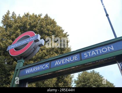 LONDON, Großbritannien - 21. JUNI 2021: Eingang zur U-Bahn-Station Warwick Avenue London. Ansicht aus niedrigem Winkel. Grauer Himmel. Stockfoto