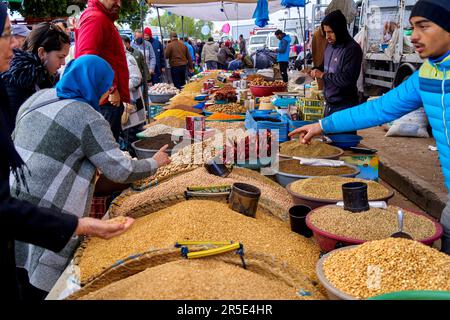 Sousse, Tunesien, 22. Januar 2023: Kunden untersuchen Waren an einem Verkaufsstand, der Saatgut, Nüsse, Getreide und anderes Getreide auf dem lokalen Markt in Souss verkauft Stockfoto