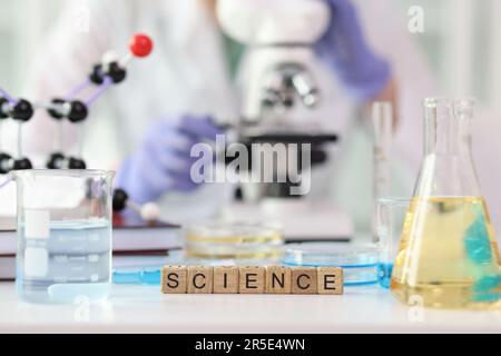 Word Science aus Würfeln in der Nähe von Laborgeräten Stockfoto