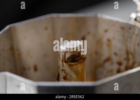 Kaffee in Mokapot, Kaffeecreme in Moka-Kanne aus der Nähe gekocht. Kaffee fließt in die Kaffeemaschine. Stockfoto
