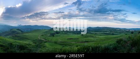 Panoramablick auf Kaukasusberge und Grasland bei Sonnenuntergang in der Region Akusha, Republik Dagestan, Föderation Russland Stockfoto