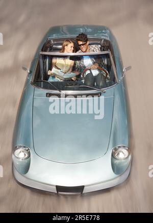 Ich hätte mir keinen besseren Tag wünschen können. Blick aus dem großen Winkel auf ein junges Paar, das eine Reise in seinem Sportwagen genießt. Stockfoto