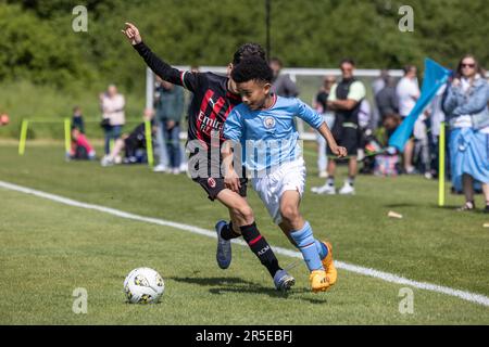 Jungen, die an sonnigen Tagen in Großbritannien Fußball und Basketball organisieren. Stockfoto