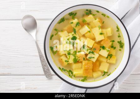 Zuppa imperiale ist eine einfache, aber köstliche Suppe aus einer reichhaltigen Hühnerbrühe, abgerundet mit Würfeln gebackenen Griemens und Parmesan-Nahaufnahme auf dem Teller Stockfoto