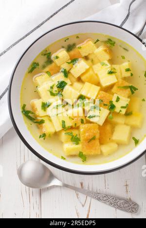 Zuppa Imperiale Italienische Imperialsuppe mit Eiern und Parmesankäse, Gericht von Emilia Romagna auf dem Teller auf dem Tisch. Vertikale Draufsicht von Stockfoto