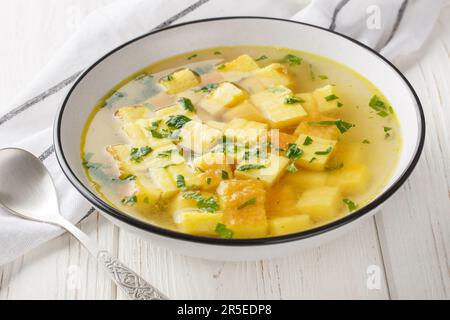 Zuppa imperiale italienische Suppe aus Hühnerbrühe mit Parmesan-Eierknödeln auf dem Teller auf dem Tisch. Horizontal Stockfoto