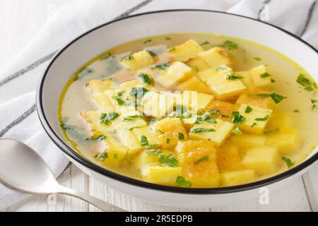 Zuppa imperiale ist eine einfache, aber köstliche Suppe aus einer reichhaltigen Hühnerbrühe, abgerundet mit Würfeln gebackenen Griemens und Parmesan-Nahaufnahme auf dem Teller Stockfoto