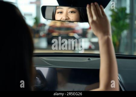 Eine charmante junge Frau sitzt hinter dem Steuer des Autos Stockfoto