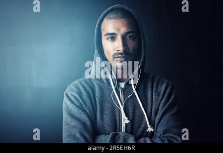 Fit zu werden ist meine oberste Priorität. Studioporträt eines jungen Mannes, der mit gefalteten Armen vor einem dunklen Hintergrund steht. Stockfoto