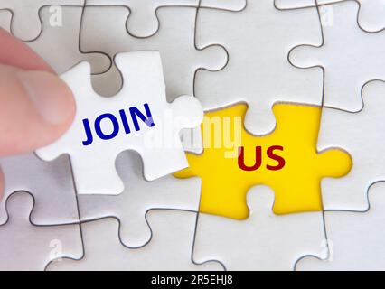 „Join US“-Text zu fehlendem Puzzle auf gelbem Hintergrund. Stockfoto