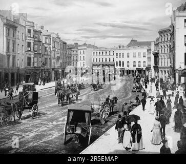 Ein Blick aus dem späten 19. Jahrhundert auf die Patrick Street, die Haupteinkaufsstraße der Stadt Cork, Irland. Die Straße stammt aus dem späten 18. Jahrhundert, als sich die Stadt über die Mauern der antiken Stadt hinaus erstreckte, die sich auf der Nord- und der Süd-Hauptstraße befand. Stockfoto