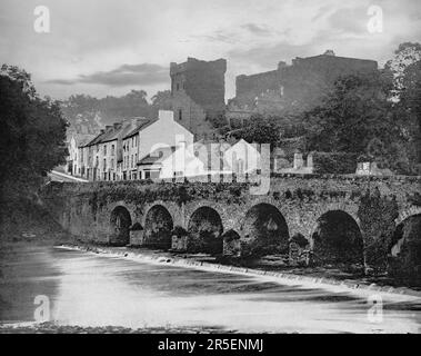 Ein Blick aus dem späten 19. Jahrhundert auf Macroom, eine Marktstadt in der Grafschaft Cork, Irland. Macroom begann als Treffpunkt für die Druiden von Munster aus dem 6. Jahrhundert und veranstaltete später eine große Schlacht c. 987 mit dem irischen König Brian Boru. Hinter der Brücke über den Fluss Sullane befindet sich Macroom Castle, das belagert, verbrannt und wieder aufgebaut wurde. Stockfoto