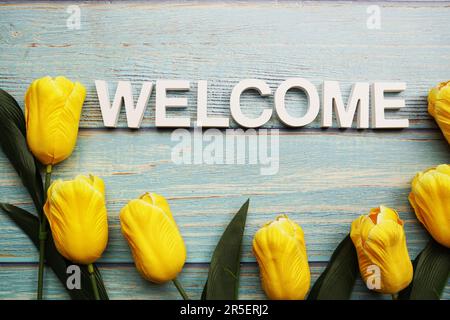 Begrüßungsbriefe mit gelber Tulpenblume auf Holzhintergrund Stockfoto