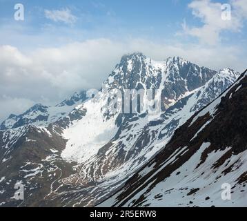 Juni Blick von der Karlesjoch Alpen Berg (3108 m, in der Nähe der Kaunertal Gletscher auf Austria-Italy Grenze) über den Abgrund und Wolken. Stockfoto