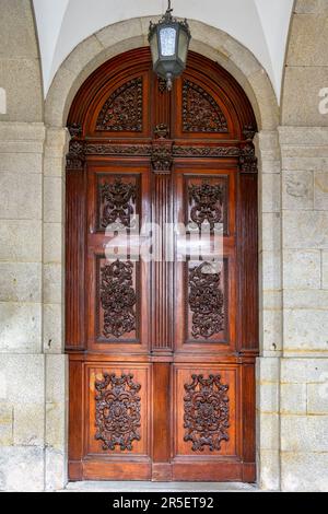 Holztür mit Schnitzereien. Architektur in Porto, Portugal. Stockfoto