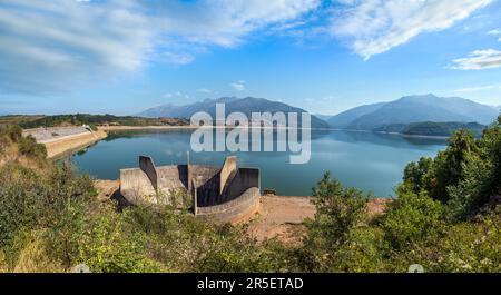 Die Sommerlandschaft des Sees mit Wasserentwässerungsbau in der Nähe des Wasserkraftwerks Shpilje und im Hintergrund der Berge zu erkunden. Nordmazedonien nicht weit Stockfoto