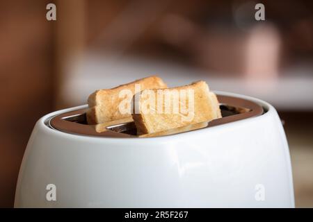 Moderner Toaster mit knusprigen Brotscheiben, Nahaufnahme Stockfoto