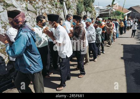 Muslime und alle Dorfbewohner schütteln sich die Hand und gratulieren Buddhisten, die den heiligen Tag des Vesaks im Dorf Thekelan, der Republik Semarang, Indonesien, feiern. Stockfoto