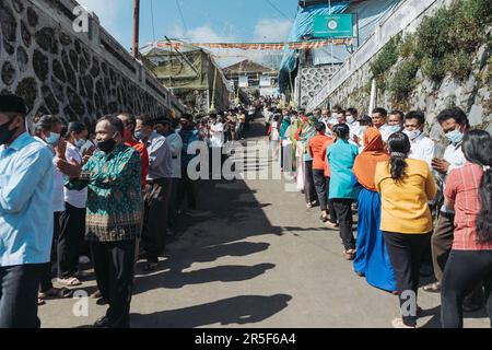 Muslime und alle Dorfbewohner schütteln sich die Hand und gratulieren Buddhisten, die den heiligen Tag des Vesaks im Dorf Thekelan, der Republik Semarang, Indonesien, feiern. Stockfoto