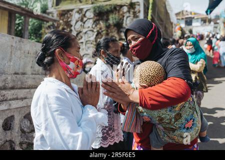 Muslime und alle Dorfbewohner schütteln sich die Hand und gratulieren Buddhisten, die den heiligen Tag des Vesaks im Dorf Thekelan, der Republik Semarang, Indonesien, feiern. Stockfoto