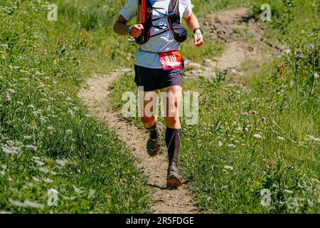 Sportler laufen auf dem Trail Marathon-Rennen, seine Füße kratzen, Blut und Schmutz vom Sturz Stockfoto