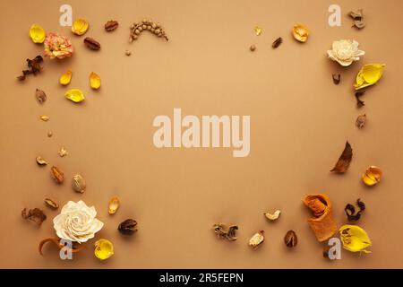 Herbstzusammensetzung mit getrockneten Blüten, Blättern und Beeren auf hellbraunem Hintergrund. Flacher Kopierbereich. Stockfoto