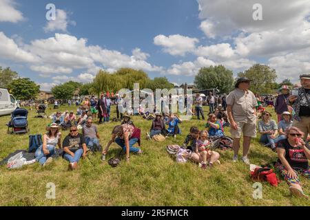 Cambridge, Großbritannien. Juni 2023. Besucher entspannen sich auf dem Gras am Fluss Cam während der Strawberry Fair, dem berühmten Free Arts and Music Festival von Cambridge, das jährlich am Midsummer Common stattfindet. Familien, Freunde und Festivalbesucher genießen das warme Juniwetter in der Nähe von Kanalbooten und Gemeinschaftsbuden. Die Messe wird ausschließlich von Freiwilligen geleitet und zelebriert lokale Kreativität, Musik und Kultur der Basis. Die Strawberry Fair 2023. Penelope Barritt/Alamy Live News Stockfoto