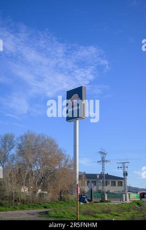 Leuchtender Wegweiser zur Repsol-Tankstelle bei Tag senkrecht mit blauem Himmel und Wolken Stockfoto