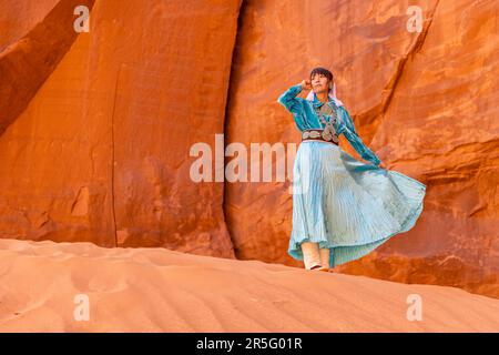 Junge indianische Navajo-Frau am Big Hogan Arch im Monument Valley Navajo Tribal Park, Arizona, USA Stockfoto