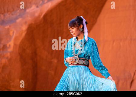 Junge indianische Navajo-Frau am Big Hogan Arch im Monument Valley Navajo Tribal Park, Arizona, USA Stockfoto