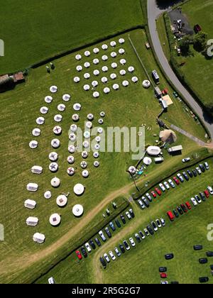 Blick aus der Vogelperspektive auf den luxuriösen Glamping-Campingplatz mit Jurten-Tipis und Zelten in der Nähe eines Festivalgeländes in Wales, Großbritannien Stockfoto