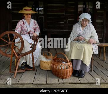 Historische Reendarsteller zeigen, wie frühe amerikanische Pionierinnen bei einer lebendigen Geschichtsveranstaltung in Abingdon, Virginia, Kleidungsstücke aus Wolle hergestellt haben. Stockfoto