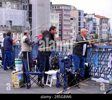 Fischer, die im Fluss Halic von der Galata-Brücke im Zentrum von Istanbul, der Türkei oder der Republik Türkiye fischen. Stockfoto