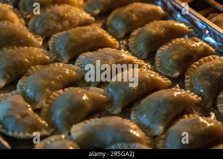 Ein Tablett mit ungekochten Curry-Puffs im Ofen Stockfoto