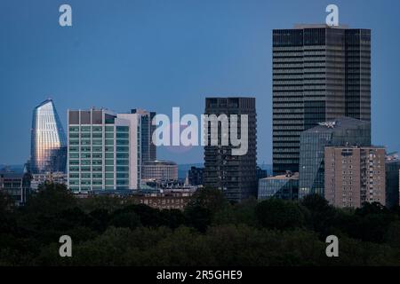 Der Blick vom Primrose Hill in London auf den Vollmond, auch bekannt als der Erdbeermond, der über der City of London aufsteigt. Foto: Samstag, 3. Juni 2023. Stockfoto