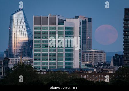 Der Blick vom Primrose Hill in London auf den Vollmond, auch bekannt als der Erdbeermond, der über der City of London aufsteigt. Foto: Samstag, 3. Juni 2023. Stockfoto