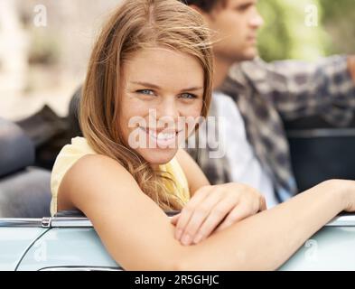 Freizeit mit meinem Mann. Porträt einer attraktiven jungen Frau, die neben ihrem Freund in einem Cabrio sitzt. Stockfoto