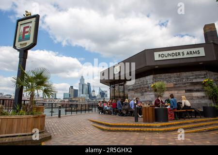 Ein allgemeiner Blick auf Menschen, die einen sonnigen Tag im Pub am Flussufer in London Southbank genießen Stockfoto