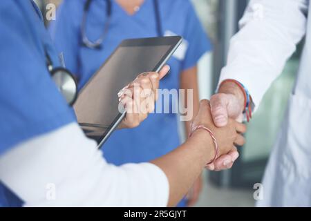 Ich verspreche dir, du kannst auf mich zählen. Eine nicht erkennbare Krankenschwester steht und schüttelt einem Arzt die Hand in der Klinik. Stockfoto
